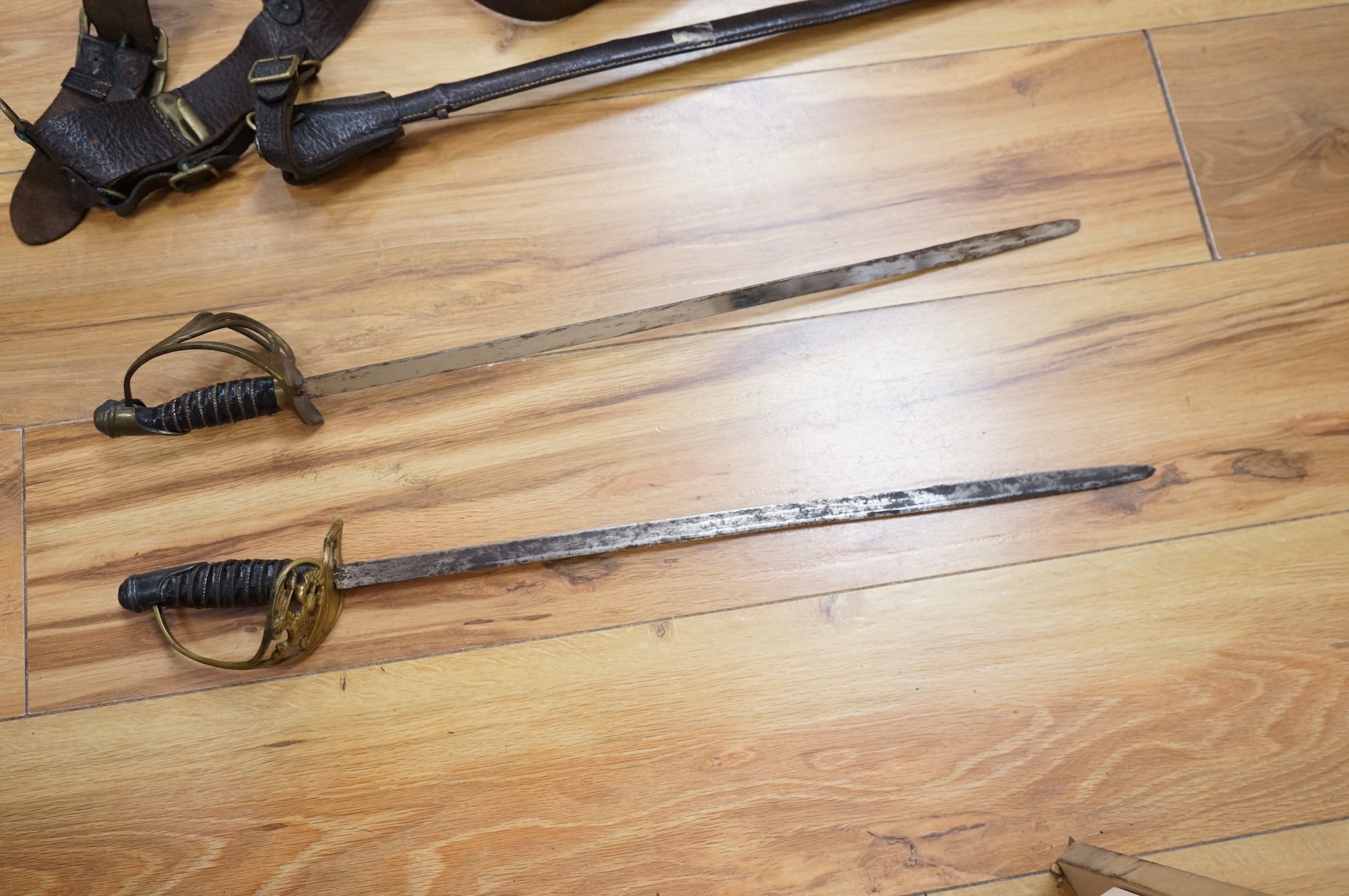 Two early 20th century Imperial German child’s swords with leather scabbards and hangers, blades 45.5cm